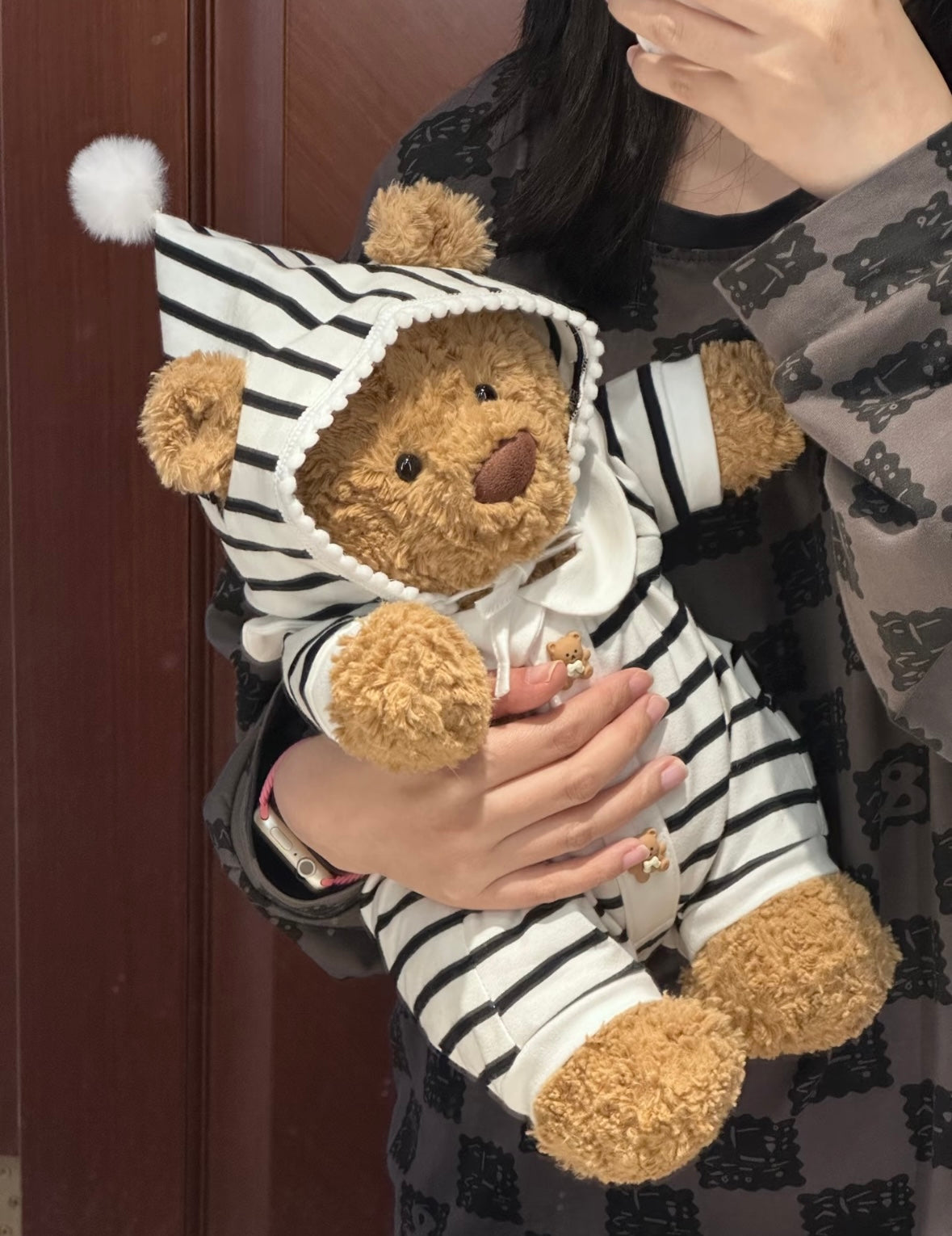 Bartholomew Bear in striped hooded romper - cradled side view