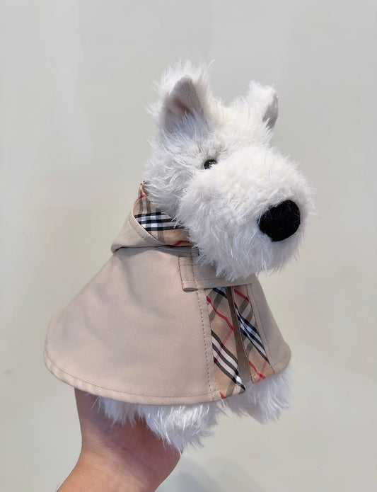 Black and white plush puppy in a stone trench cape with beige check scarf