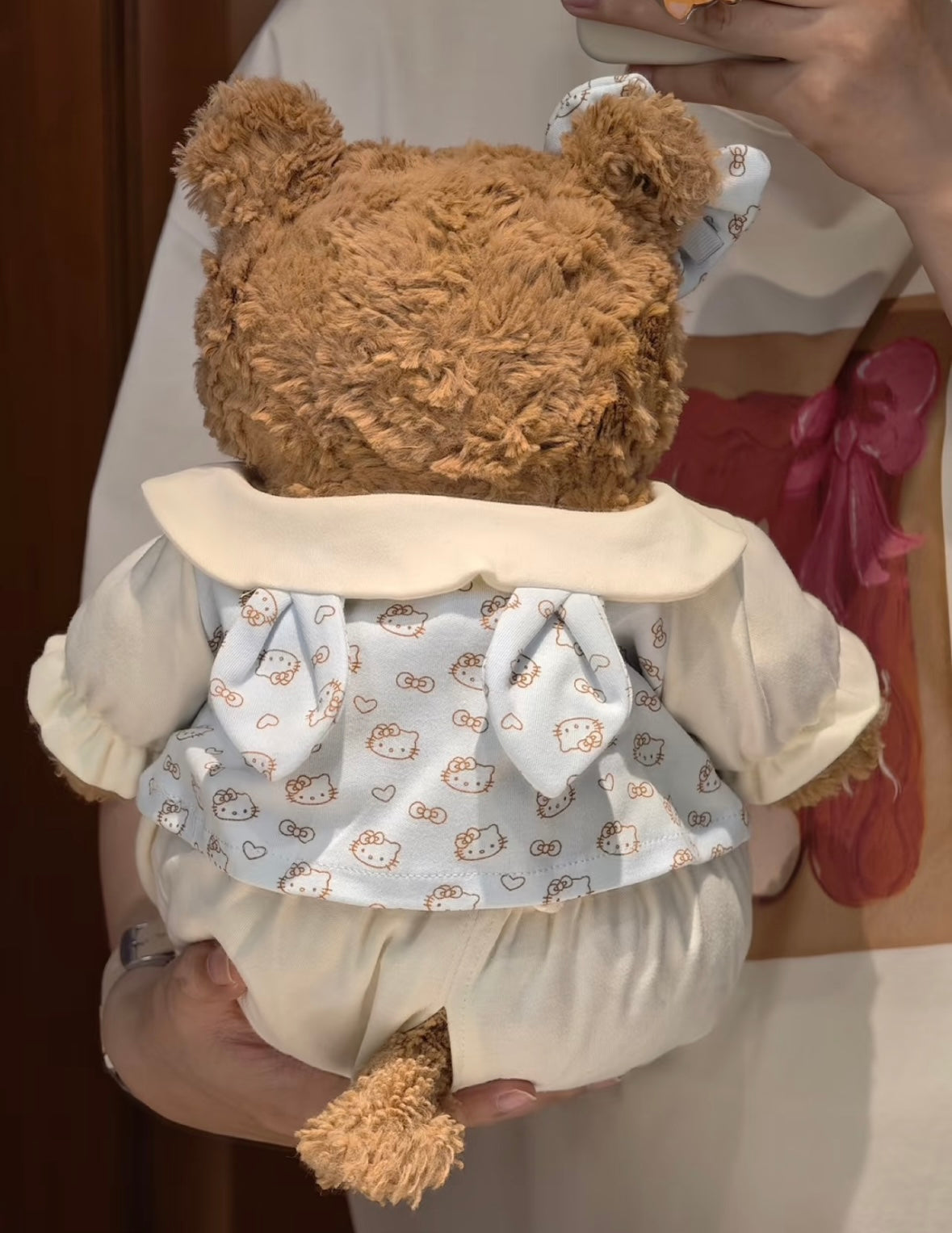 Back view of Bartholomew Bear in blue Hello Kitty romper showing bow tie detail on pinafore